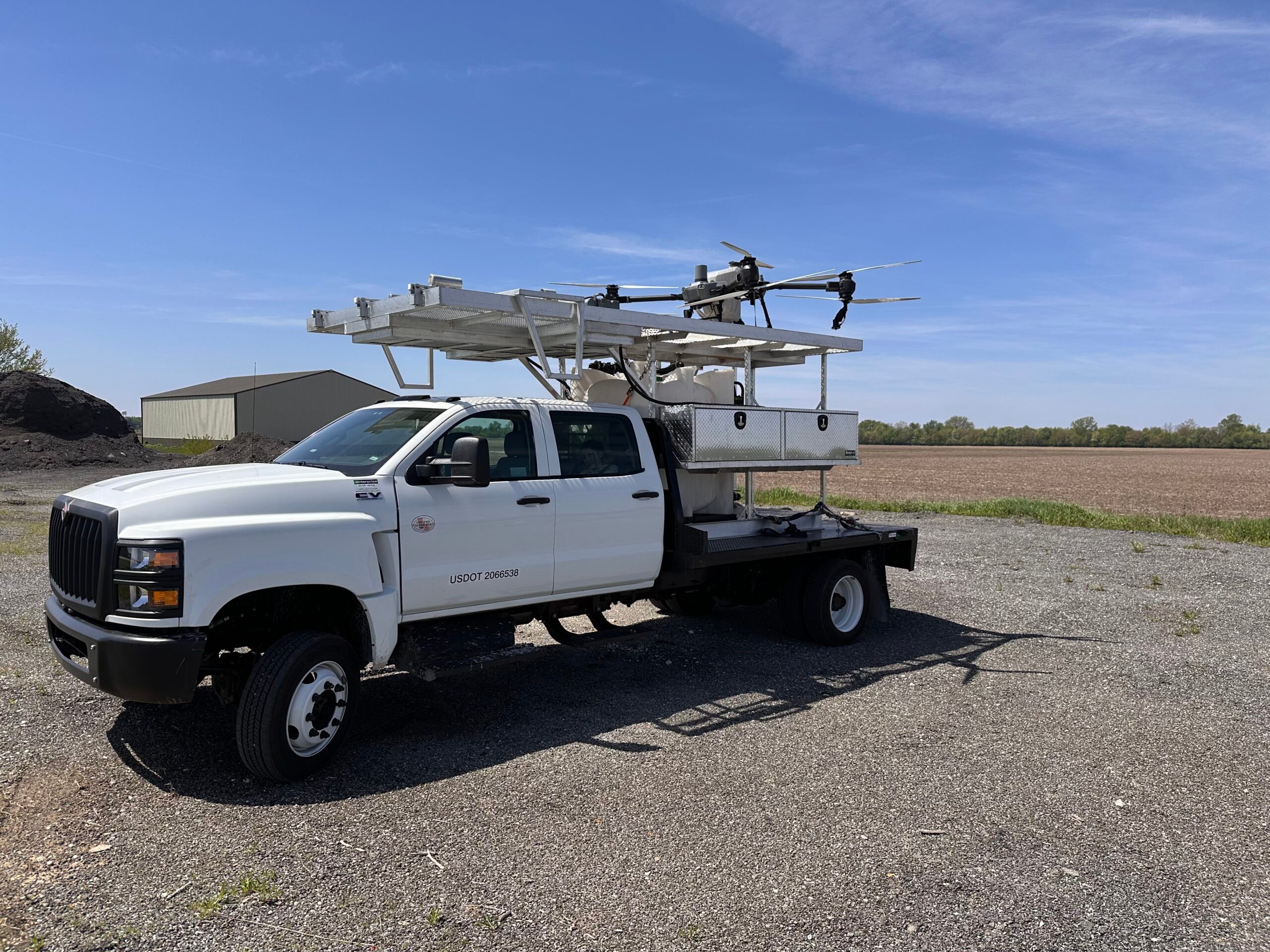 Heritage Drone Service truck outfitted with agricultural drone, mobile spray system, and support platform for on-site crop spraying services.